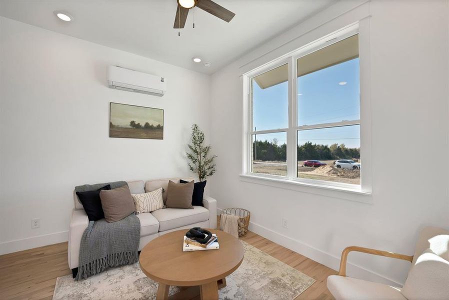 Living room with an AC wall unit, wood finished floors, recessed lighting, and a ceiling fan