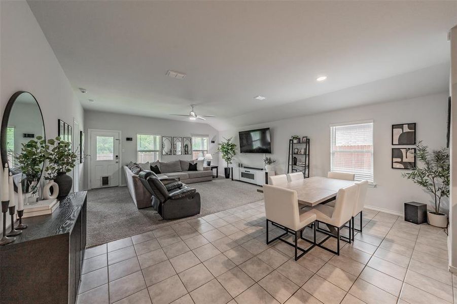 Open-concept living area with vaulted ceilings, recessed lighting, and a ceiling fan