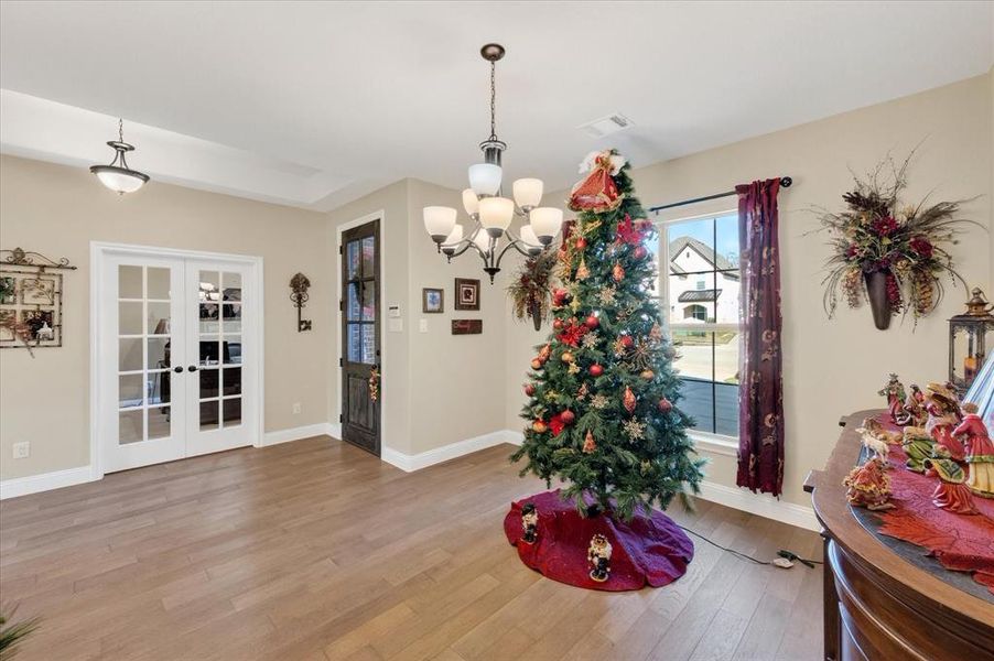 Dining space featuring french doors, light wood-style flooring, and a chandelier Dining space featuring french doors, light wood-style flooring, and a chandelier