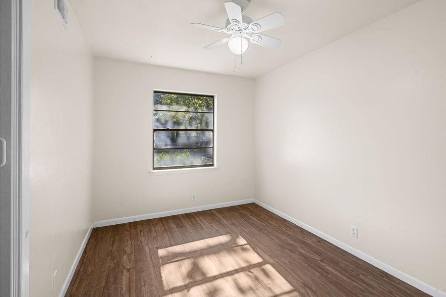 Empty room with wood finished floors and ceiling fan