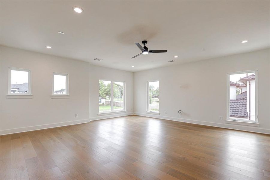 Empty room featuring a ceiling fan, hardwood / wood-style floors, and recessed lighting