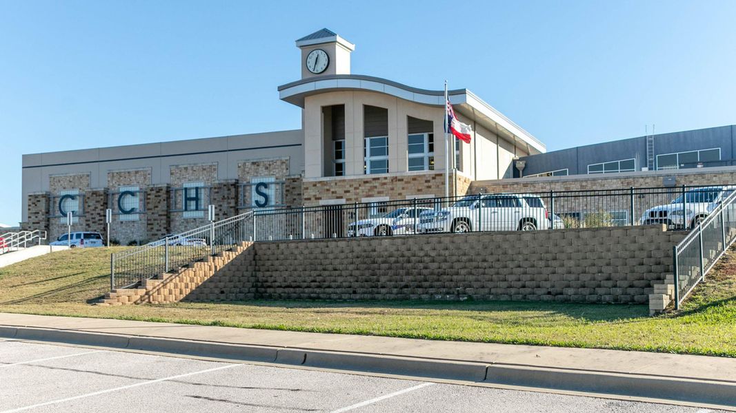 View of building exterior featuring stairway and uncovered parking