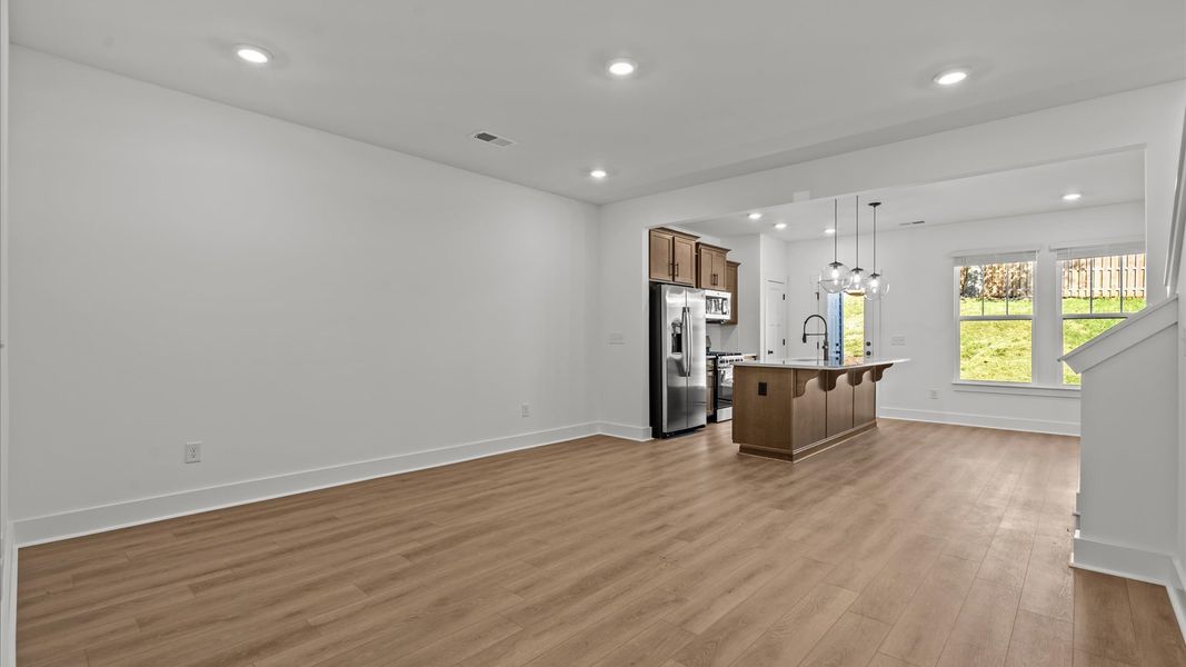 Spacious family room with rich hardwood flooring and elegant trim work in a reputable DRB Homes build