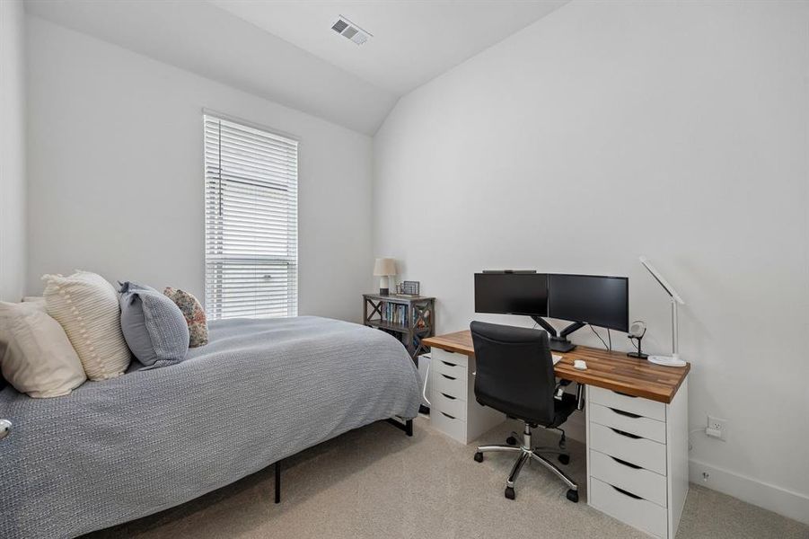 Bedroom featuring a single window with blinds, vaulted ceiling, and neutral carpeting