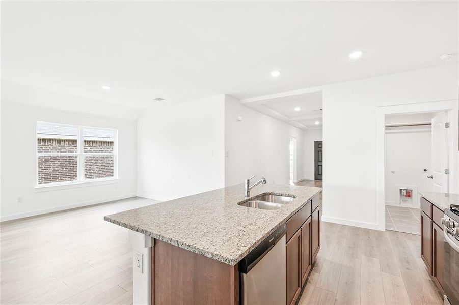 Kitchen featuring light stone counters, light wood finished floors, stainless steel appliances, healthy amount of natural light, and recessed lighting Kitchen featuring light stone counters, light wood finished floors, stainless steel appliances, healthy amount of natural light, and recessed lighting