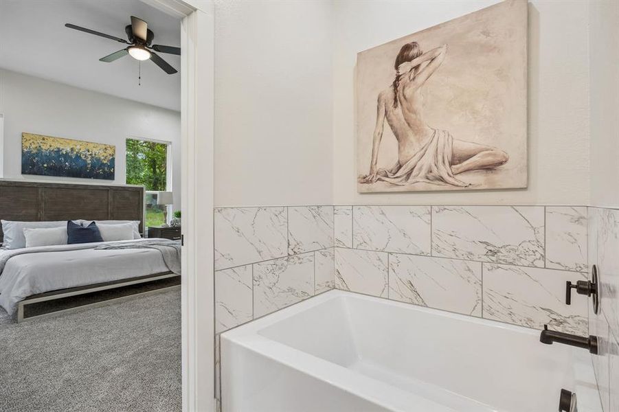 Soaking tub with black matte fixtures and subway tile surround