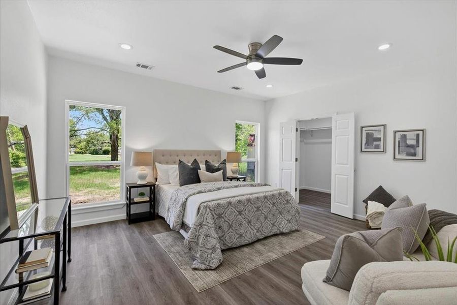 Primary bedroom featuring LVP flooring, recessed lighting, and a ceiling fan