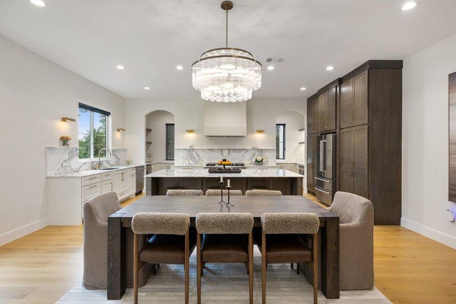 Culinary excellence meets elegant dining in this open-concept kitchen with exquisite marble and warm wood accents. Culinary excellence meets elegant dining in this open-concept kitchen with exquisite marble and warm wood accents.