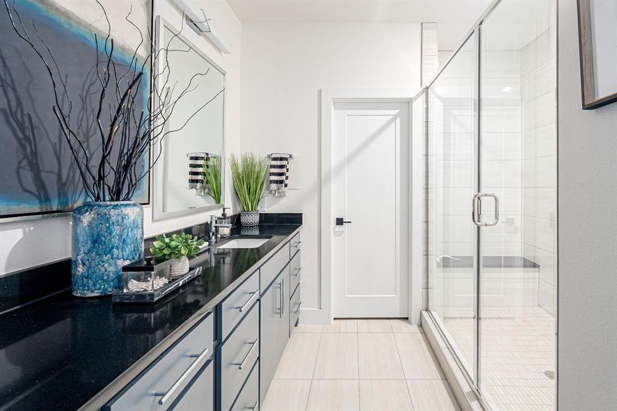 Bathroom with light tile patterned floors, a stall shower, and vanity