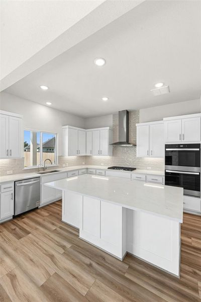 Kitchen with white cabinetry, a center island, tasteful backsplash, stainless steel appliances, and recessed lighting