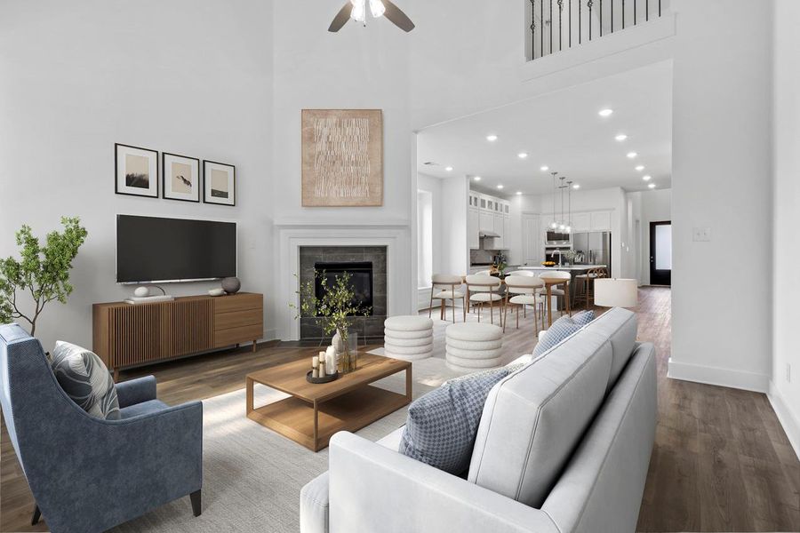 Living area featuring dark wood finished floors, a towering ceiling, recessed lighting, a fireplace, and ceiling fan Living area featuring dark wood finished floors, a towering ceiling, recessed lighting, a fireplace, and ceiling fan