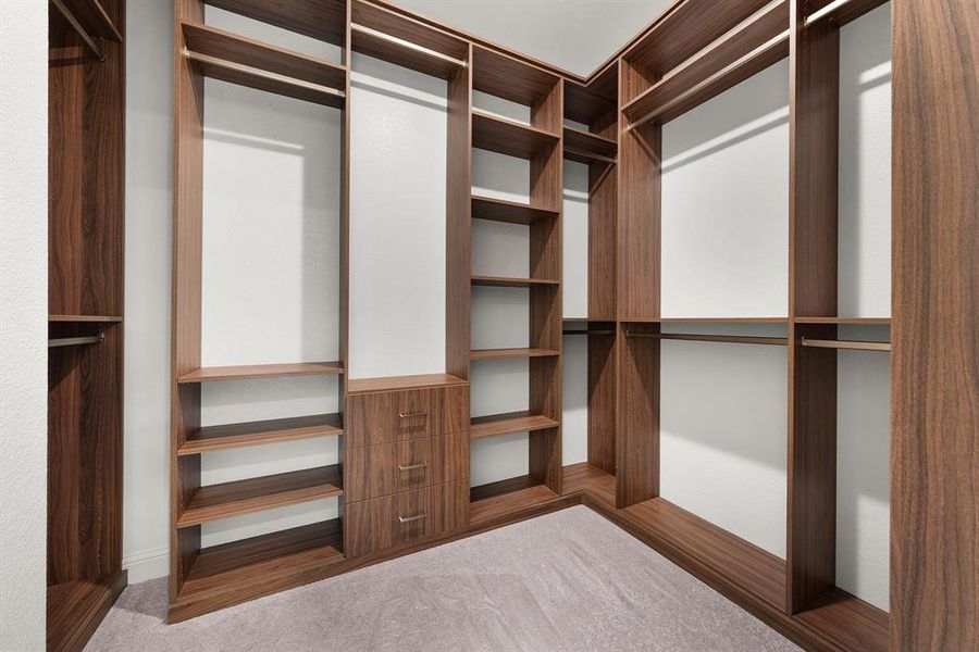 One of two primary closets customized with drawers, shelves and hanging racks. One of two primary closets customized with drawers, shelves and hanging racks.
