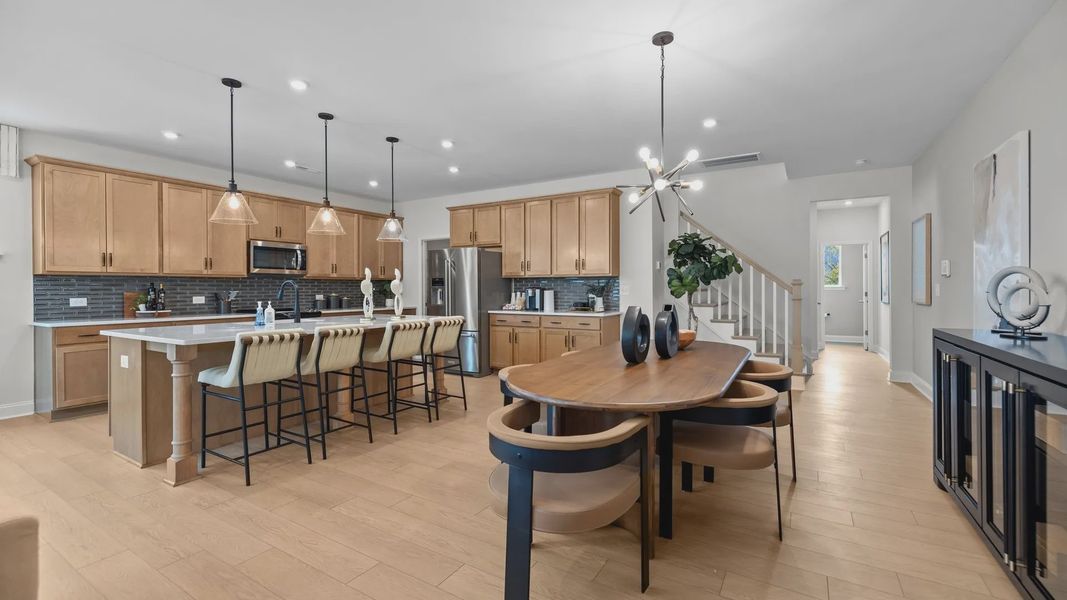 Open-Concept dining area and kitchen with premium lighting in the Adaline Plan new townhome by DRB Homes Charlotte