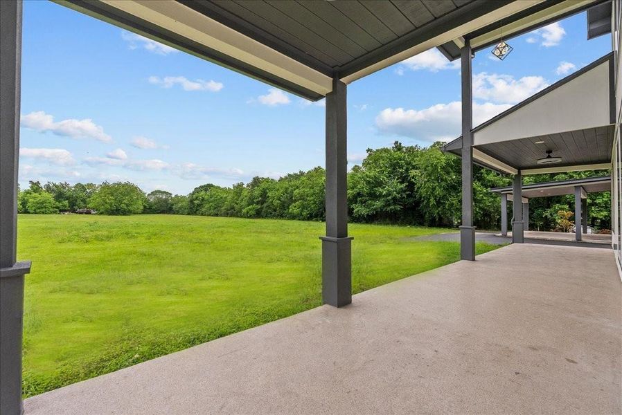 Covered outdoor patio overlooking the peaceful acreage setting.