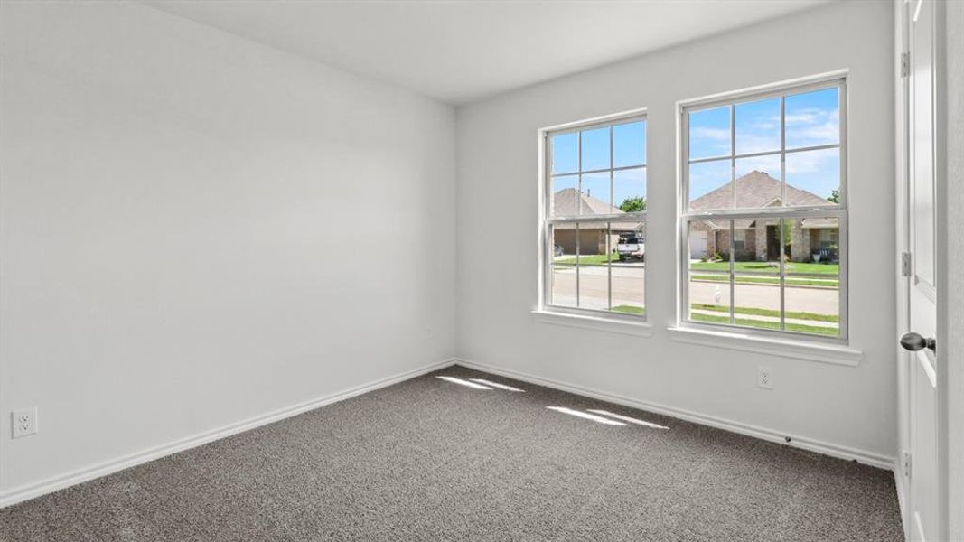 Empty room with dark carpet and baseboards