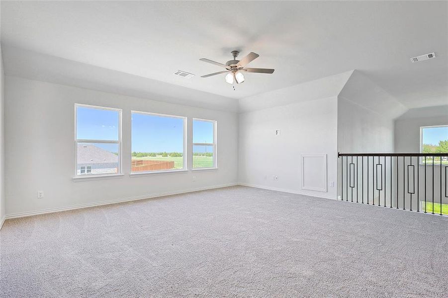 Carpeted spare room with ceiling fan