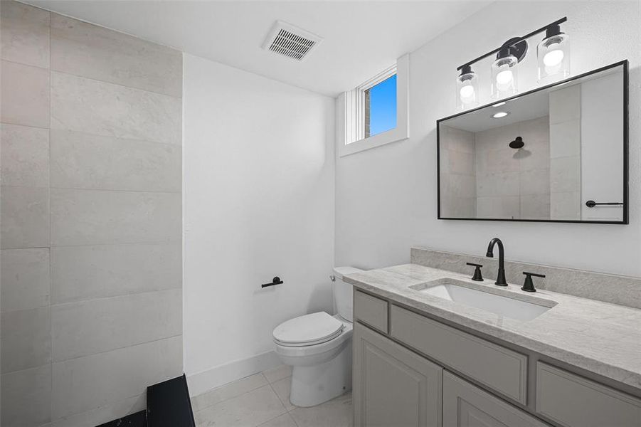 Bathroom with vanity, light tile patterned floors, and tiled shower Bathroom with vanity, light tile patterned floors, and tiled shower