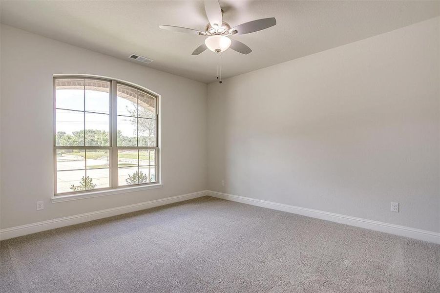 Unfurnished room featuring light colored carpet and a ceiling fan