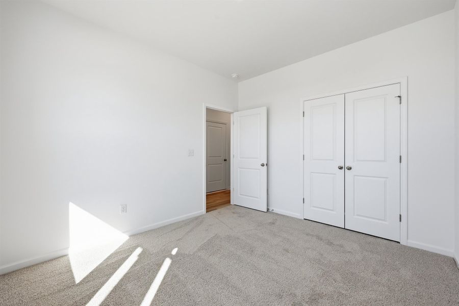 Unfurnished bedroom with carpet and a closet Unfurnished bedroom with carpet and a closet