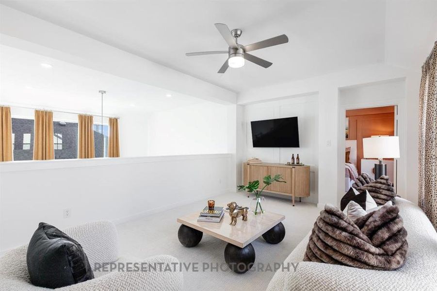 Carpeted living area with a ceiling fan and recessed lighting