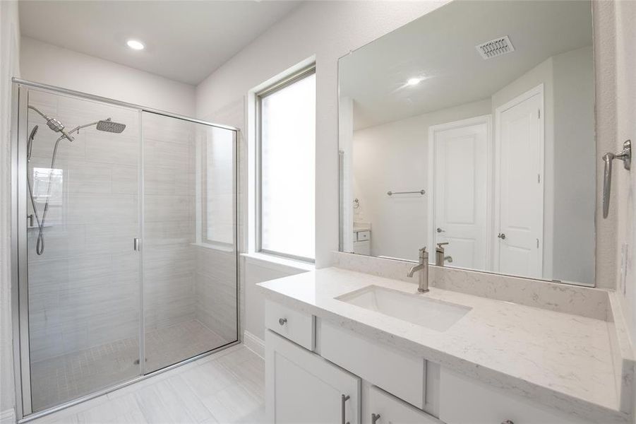 Start and end each day in this spa-inspired primary bath featuring an oversized walk-in shower, abundant counter space, and elegant finishes throughout. Start and end each day in this spa-inspired primary bath featuring an oversized walk-in shower, abundant counter space, and elegant finishes throughout.