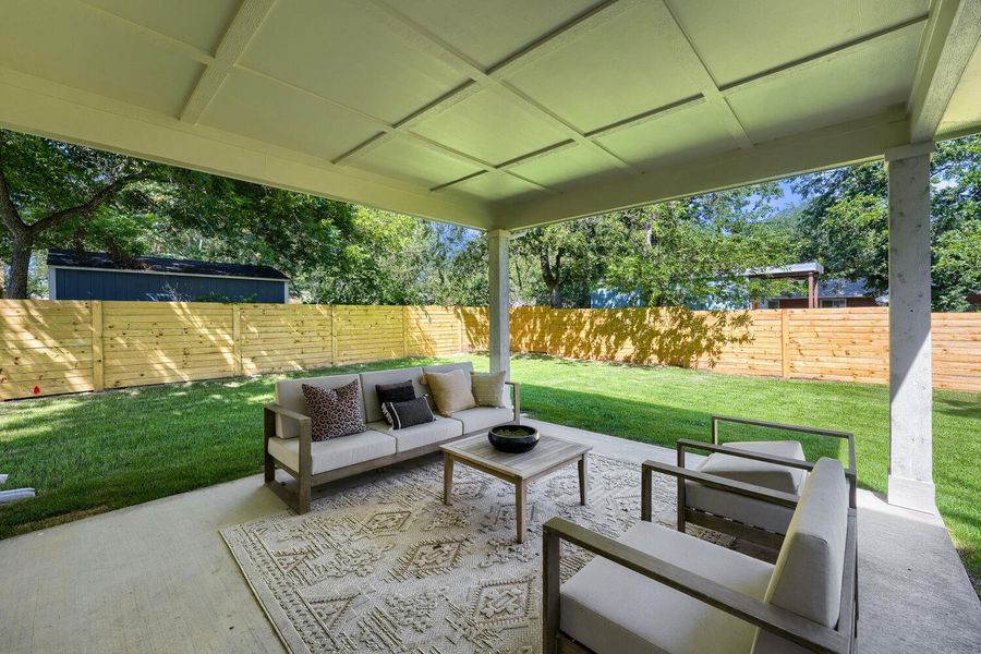 An inviting covered patio opens to a lush lawn, perfect for outdoor leisure. An inviting covered patio opens to a lush lawn, perfect for outdoor leisure.