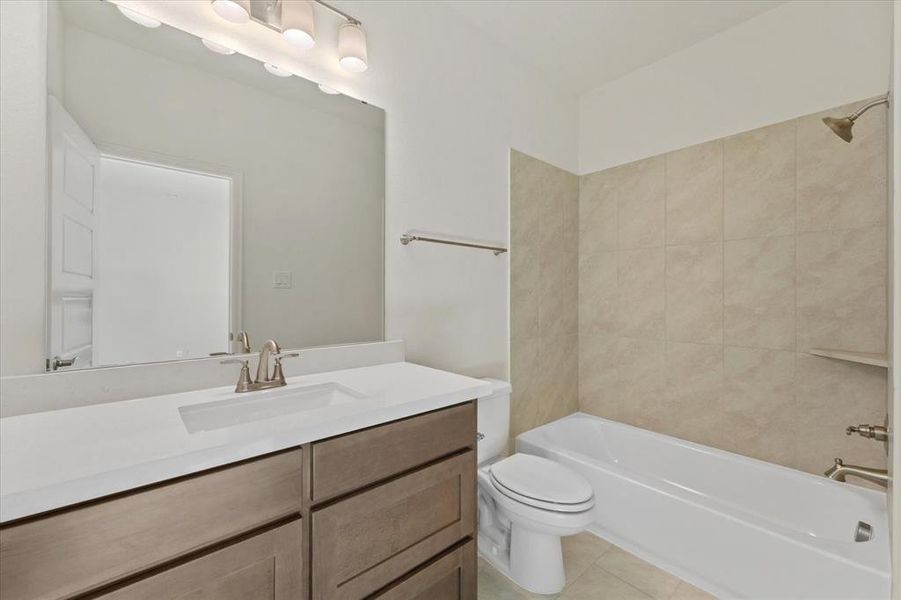 Full bathroom featuring tub / shower combination, light tile patterned floors, and vanity