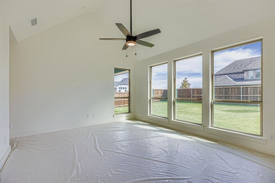 Unfurnished room with high vaulted ceiling and ceiling fan Unfurnished room with high vaulted ceiling and ceiling fan