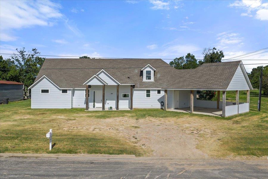 View of front facade featuring roof with shingles and a front yard View of front facade featuring roof with shingles and a front yard