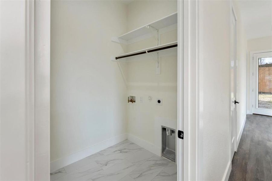 Laundry area with hookup for a washing machine, hookup for a gas dryer, and hookup for an electric dryer