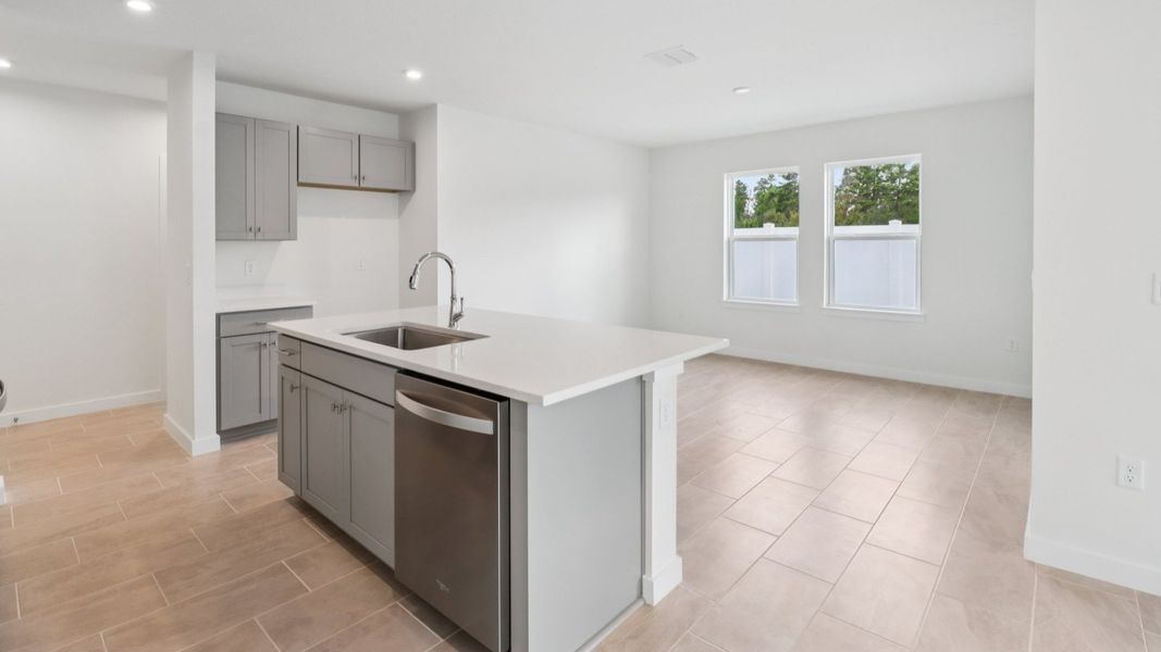Kitchen and Living Room in the Monterey End Townhome by DRB Homes - Cyrene at Harmony in St Cloud FL