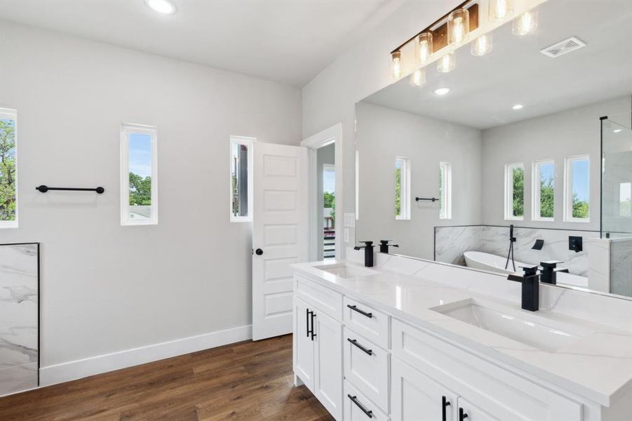 Bathroom with vanity, hardwood / wood-style flooring, and a washtub