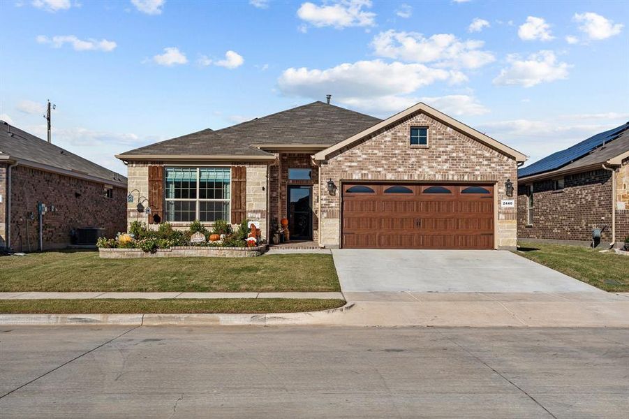 View of front of property with a garage and a front lawn