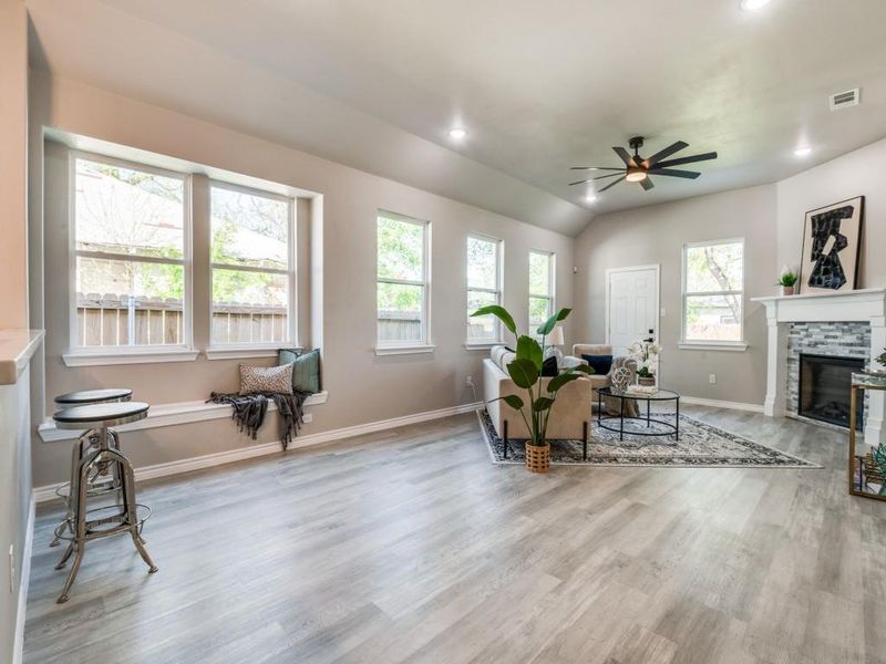 Living area featuring wood finished floors, visible vents, a ceiling fan, and a healthy amount of sunlight Living area featuring wood finished floors, visible vents, a ceiling fan, and a healthy amount of sunlight