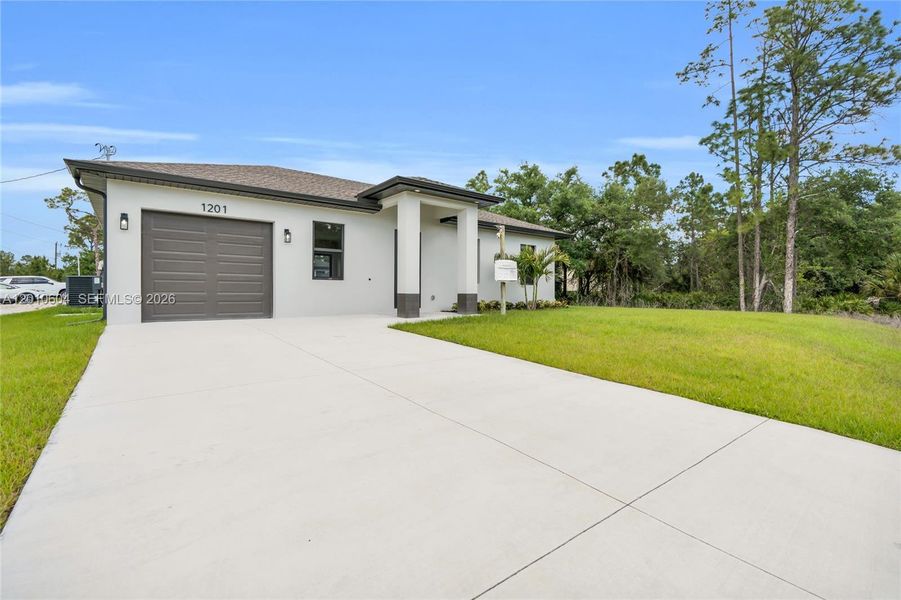 Front exterior of a new home in , Lehigh Acres, FL, highlighting curb appeal (Image 26).