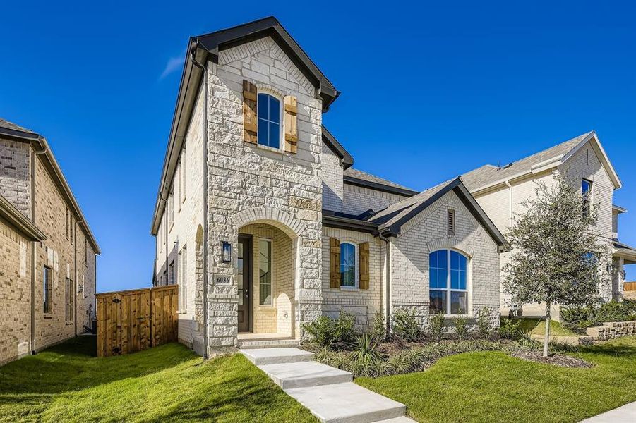 French provincial home featuring stone siding and brick siding