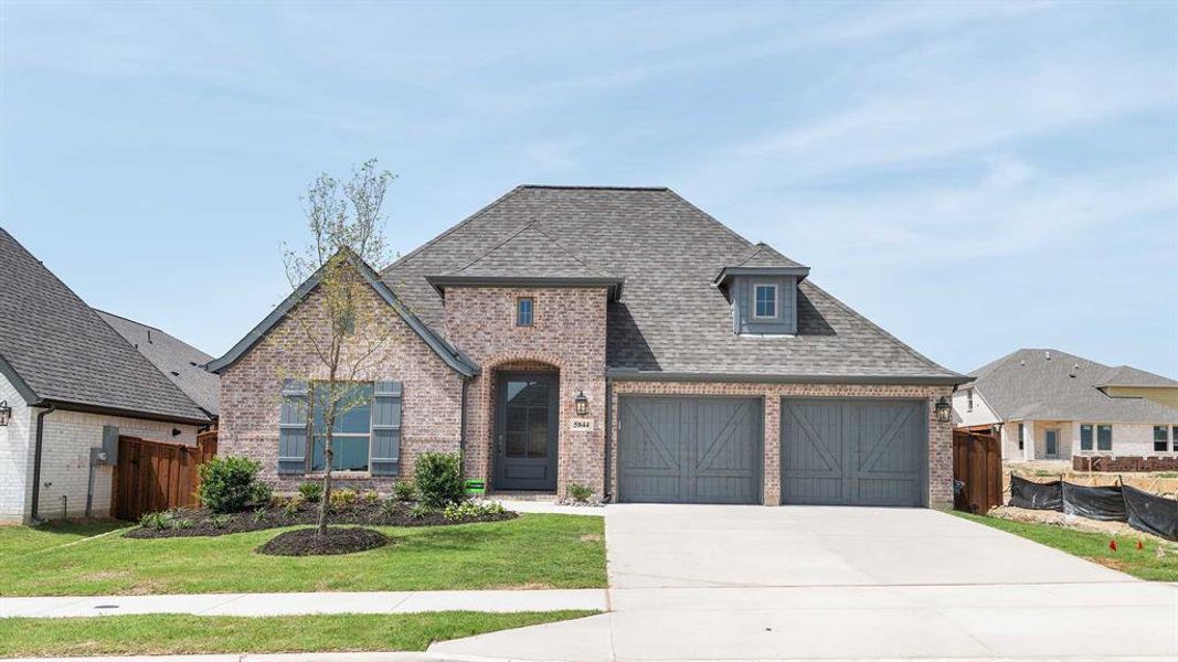 View of front facade featuring a garage and a front yard