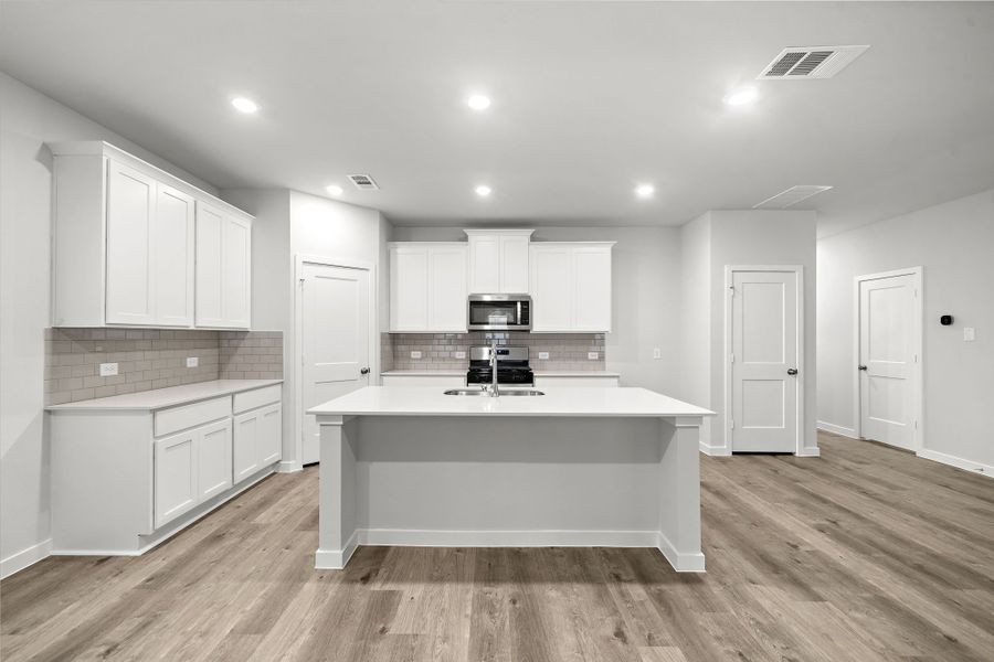 A kitchen with white cabinets.
