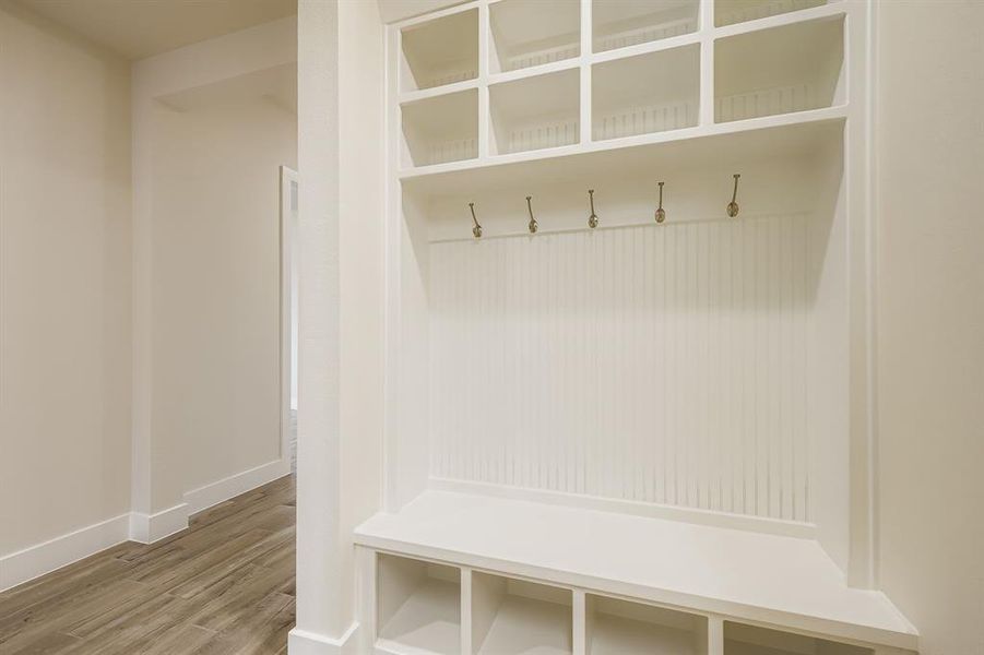 Mudroom with wood finished floors and baseboards