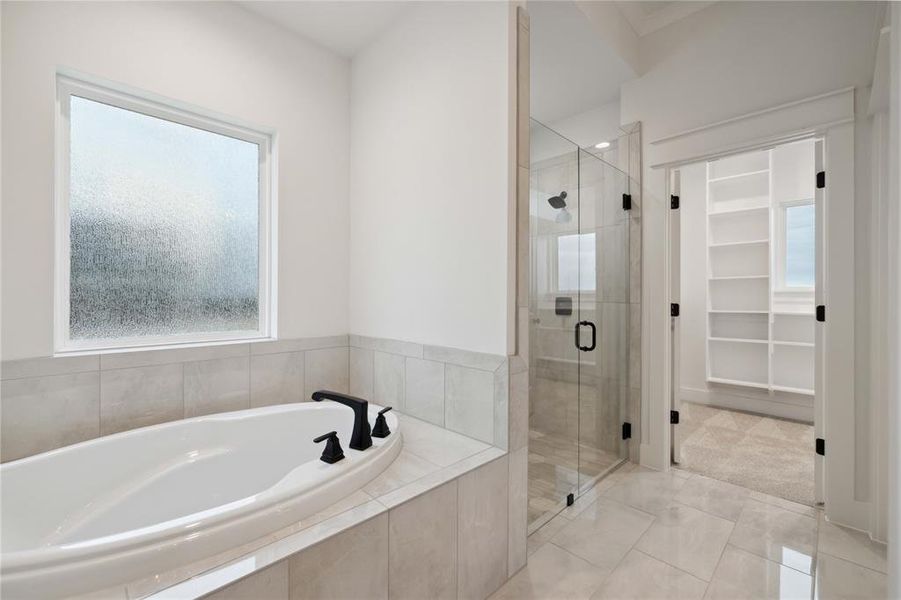 Bathroom featuring tile patterned floors, independent shower and bath, and a wealth of natural light