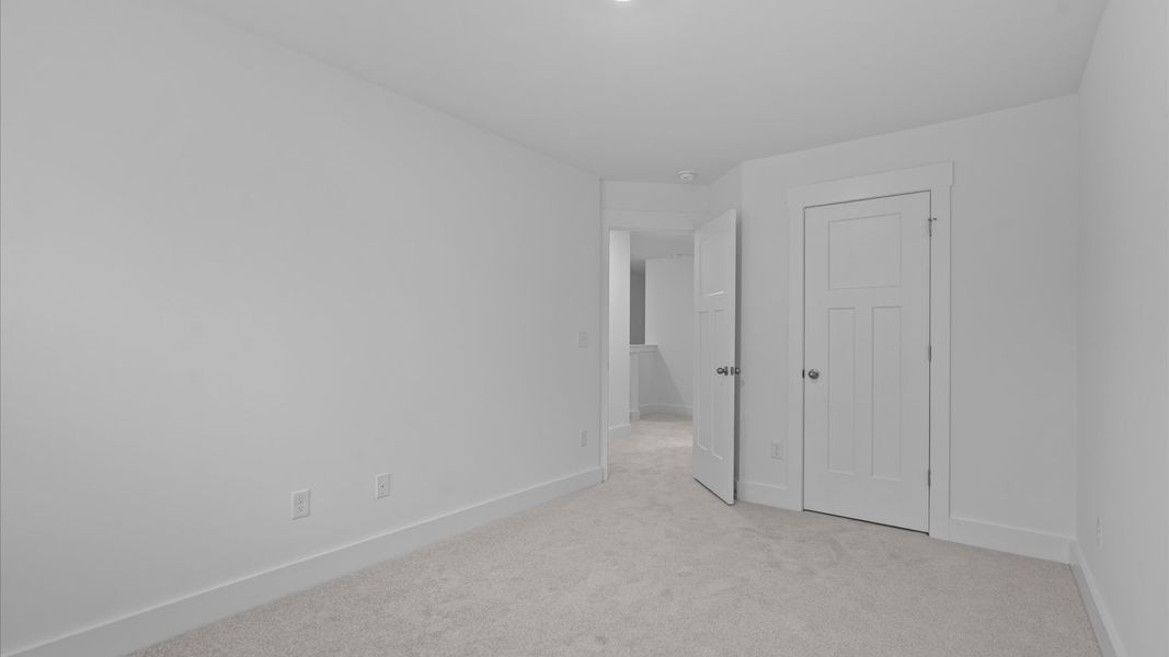 Elegant bedroom retreat featuring soft carpeting and a thoughtfully designed walk-in closet Elegant bedroom retreat featuring soft carpeting and a thoughtfully designed walk-in closet