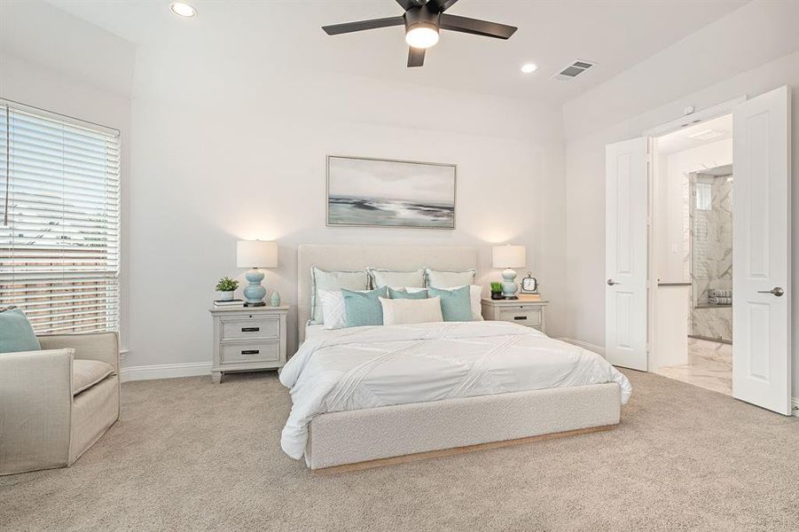 Primary bedroom with ceiling fan and ensuite bathroom