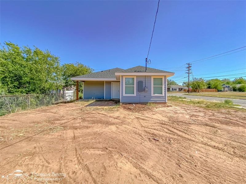 View of back of house featuring a shingled roof View of back of house featuring a shingled roof