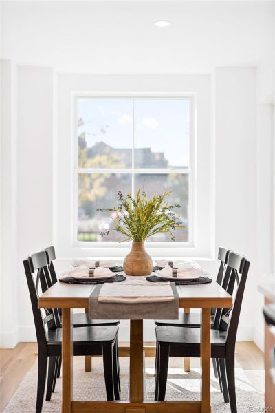A bright dining nook framed by large windows offers a serene setting for everyday gatherings.