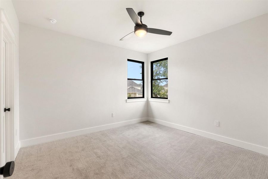 A quiet corner bedroom with twin corner windows offers tranquil neighborhood views.