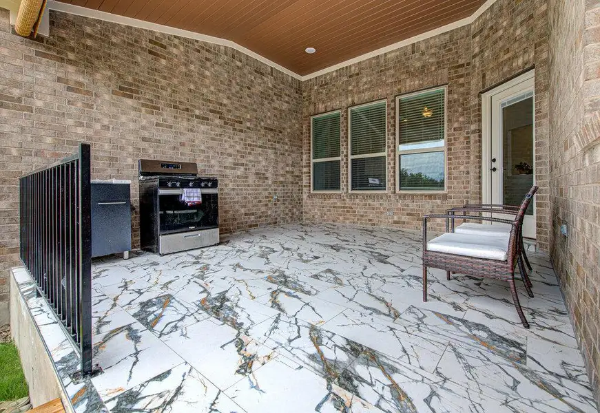 Polished tile flooring and brick walls define this covered back patio space. Polished tile flooring and brick walls define this covered back patio space.