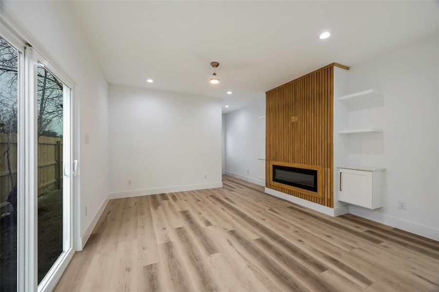 Unfurnished living room featuring light wood-type flooring and a fireplace