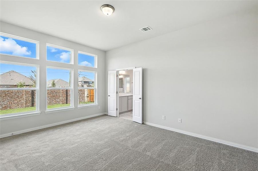 Unfurnished bedroom featuring carpet floors and connected bathroom Unfurnished bedroom featuring carpet floors and connected bathroom