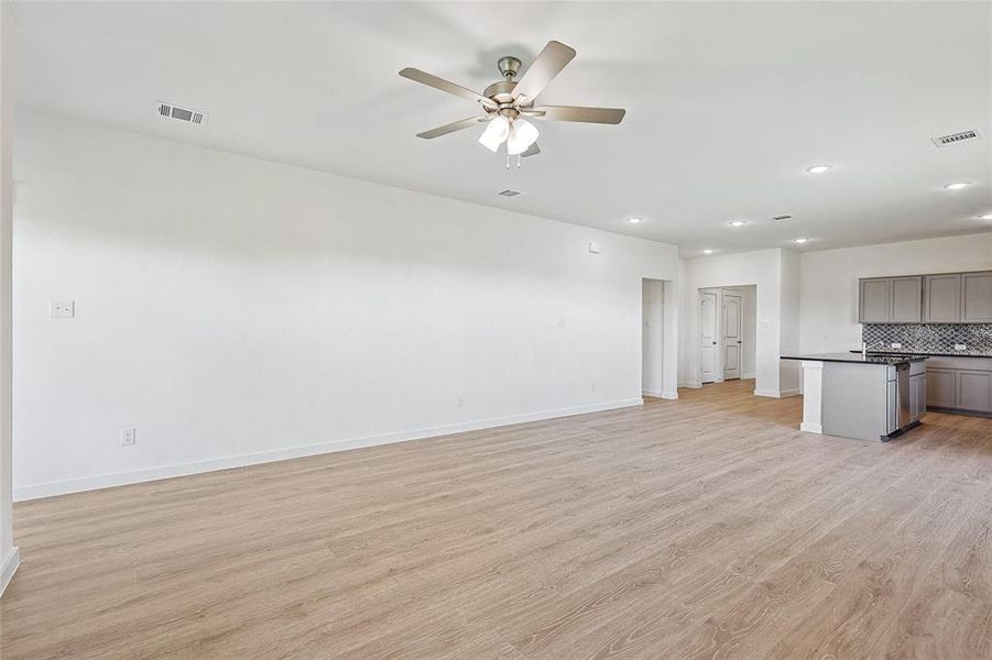 Unfurnished living room with ceiling fan and light hardwood / wood-style floors