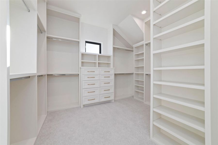 Large custom walk-in closet with built-in shelving and storage.